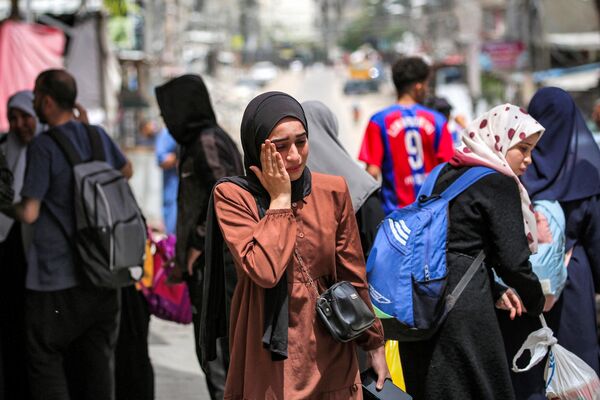 A woman reacts as she wait with others before evacuating from Rafah in the southern Gaza Strip on May 11, 2024 amid the ongoing conflict in the Palestinian territory between Israel and Hamas. - Sputnik Africa