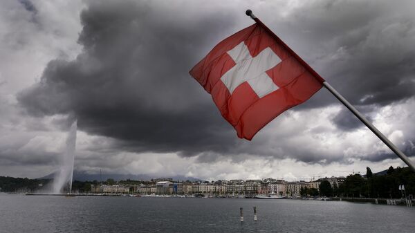 A Swiss flag flies on the shores of Geneva Lake in front of the Geneva Fountain (L) on June 14, 2013 in the center of Geneva - Sputnik Africa