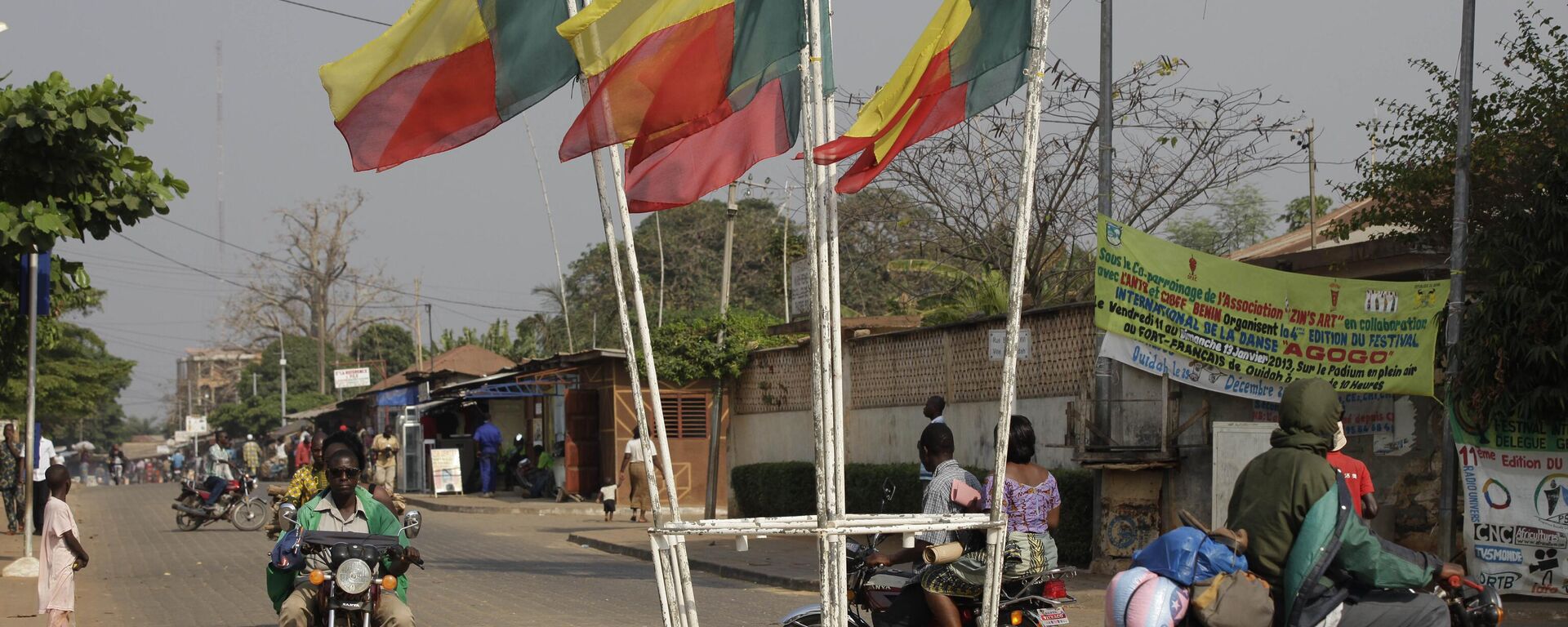People ride past Benin's national flags in Ouidah, Benin, on Wednesday, Jan. 9, 2013. - Sputnik Africa, 1920, 16.05.2024