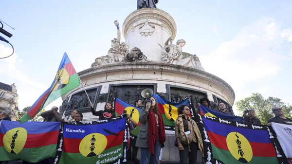 Demonstrators hold Kanak and Socialist National Liberation Front (FLNKS) flags during a gathering in Paris, Thursday May 16, 2024. - Sputnik Africa
