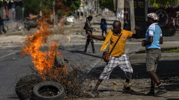 People set on fire an abandoned body, covered with branches and tires, in the Champ de Mars area of Port-au-Prince, Haiti, Saturday, May 11, 2024. - Sputnik Africa