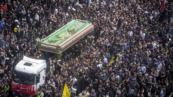 Iranians follow a truck carrying coffins of the late President Ebrahim Raisi and his companions who were killed in a helicopter crash on Sunday in a mountainous region of the country's northwest, during a funeral ceremony for them in Tehran, Iran, Wednesday, May 22, 2024.  - Sputnik Africa