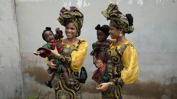 Twins Oladapo Taiwo, left, and Oladapo Kehinde, 21, pose for photographs holding relative's twins during the annual twins festival in Igbo-Ora Southwest Nigeria, Saturday, Oct. 8, 2022. - Sputnik Africa