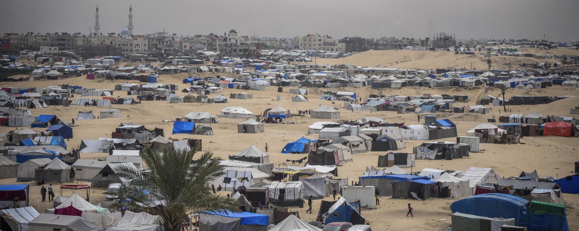 Palestinians displaced by the Israeli air and ground offensive on the Gaza Strip walk through a makeshift tent camp in Rafah, Gaza, Friday, May 10, 2024. (AP Photo/Abdel Kareem Hana) - Sputnik Africa, 1920, 27.05.2024
