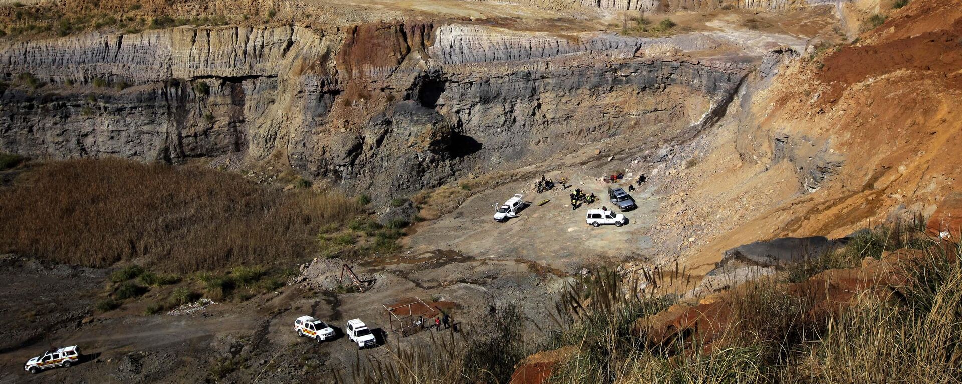 Medics and police search the scene Friday Aug. 13, 2010 where four illegal miners were found dead in an abandoned mine near Springs, South Africa, on Monday.  - Sputnik Africa, 1920, 05.12.2024