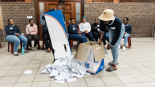 Les responsables de la Commission électorale d'Afrique du Sud vident une urne pendant le processus de dépouillement des votes au bureau de vote en Afrique du Sud à Durban le 29 mai 2024 - Sputnik Afrique