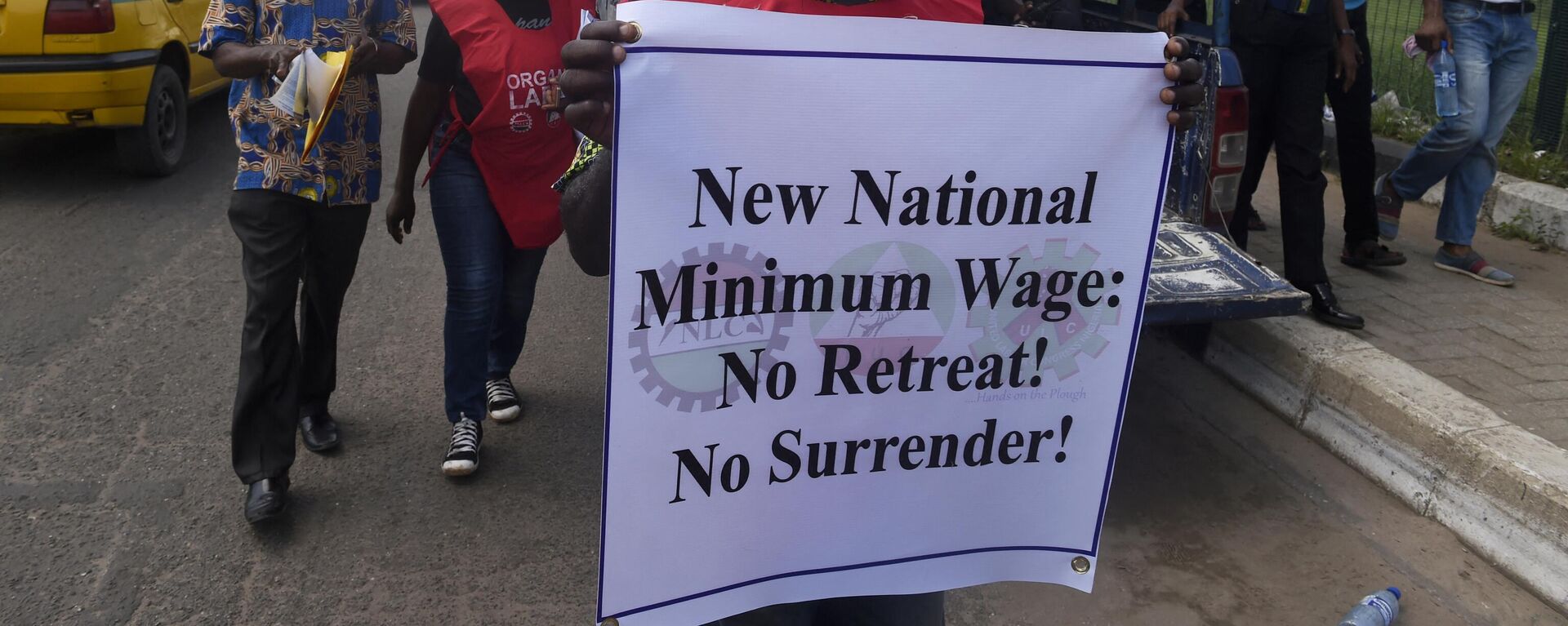 A worker holding a printed message takes part in a march to protest against the government's failure to agree on a new minimum wage during a rally in Lagos, on October 30, 2018. - Sputnik Africa, 1920, 02.06.2024