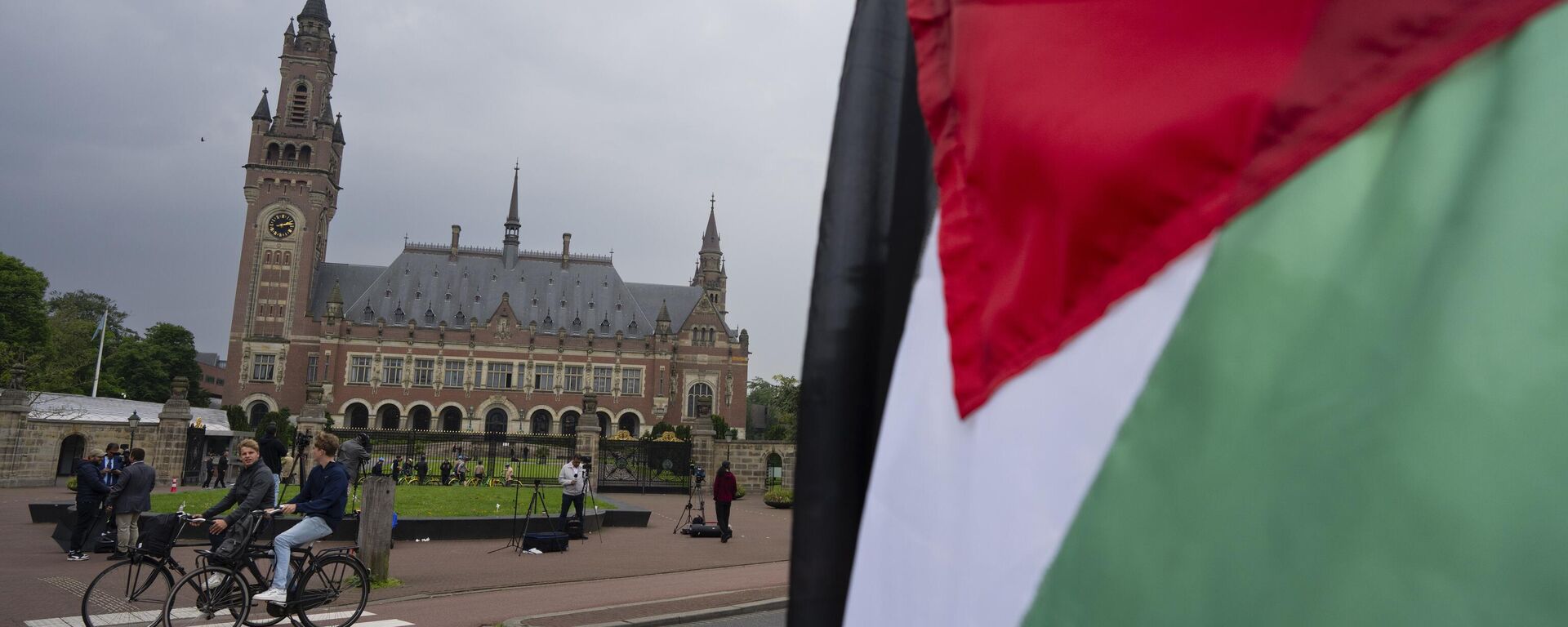 A lone demonstrator waves the Palestinian flag outside the Peace Palace, rear, housing the International Court of Justice, or World Court, in The Hague, Netherlands, Friday, May 24, 2024. - Sputnik Africa, 1920, 10.09.2024