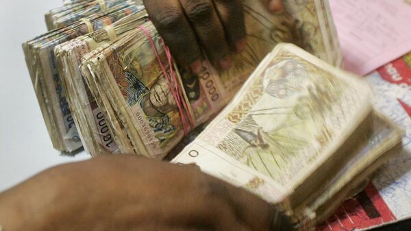A bank teller counts piles of old-style West African CFA Franc banknotes at a bank in Dakar, Senegal Monday, Sep. 13, 2004.  - Sputnik Africa