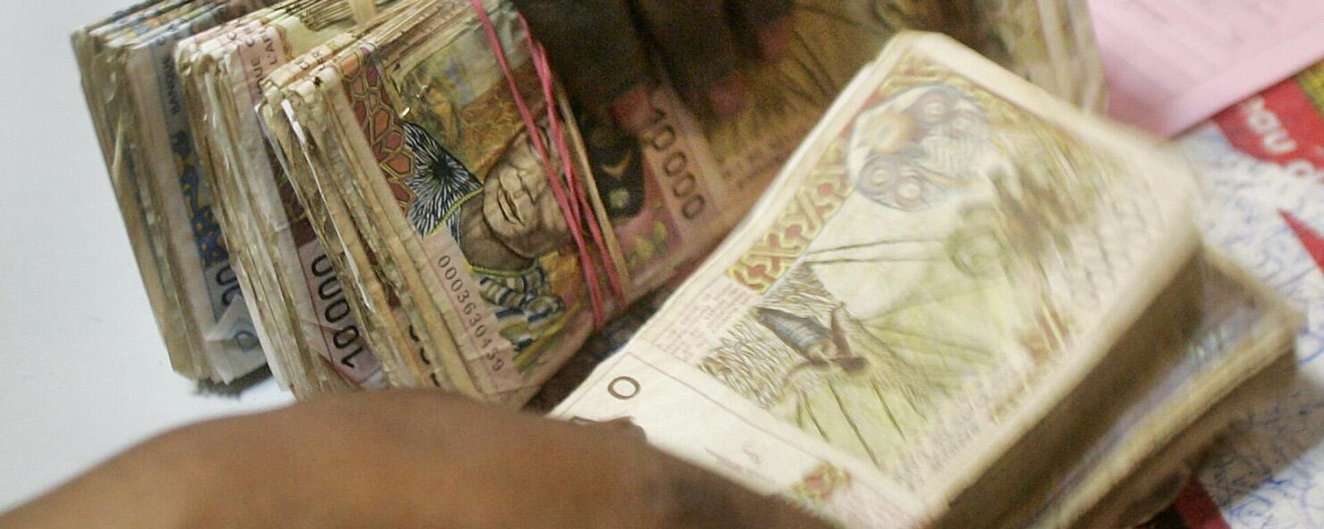 A bank teller counts piles of old-style West African CFA Franc banknotes at a bank in Dakar, Senegal Monday, Sep. 13, 2004.  - Sputnik Africa, 1920, 09.06.2024