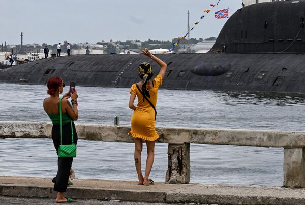 A woman waves to crew members of the nuclear-powered submarine Kazan, part of the Russian naval detachment visiting Cuba. - Sputnik Africa