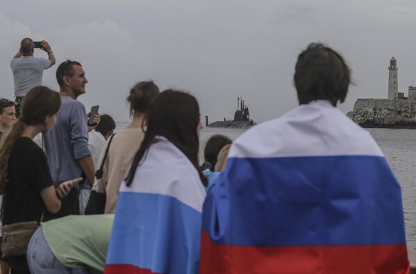 People wearing Russian flags watch the Kazan submarine arrive at the port of Havana. The Russian warships reached Cuban waters on Wednesday, ahead of planned military exercises in the Caribbean. - Sputnik Africa