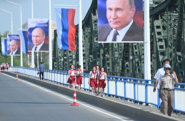 Banners with a portrait of Russian President Vladimir Putin and Russian flags on the street in Pyongyang. - Sputnik Africa