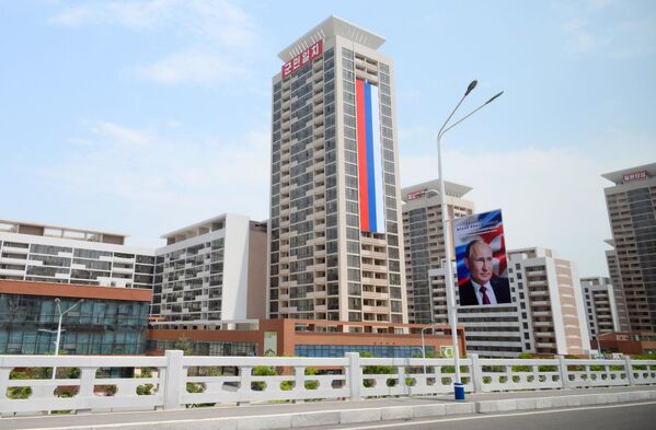 A Russian flag on a building and a banner with a portrait of Russian President Vladimir Putin on a street in Pyongyang. - Sputnik Africa