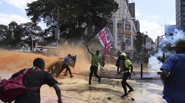 Protesters scatter as Kenya police spray water canon at them during a protest over proposed tax hikes in a finance bill in downtown Nairobi, Kenya Tuesday, June. 25, 2024. - Sputnik Afrique