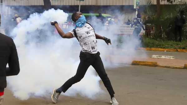 A protester throws back a tear gas canister at police officers during a protest over proposed tax hikes in a finance bill that is due to be tabled in parliament in Nairobi, Kenya, Thursday, June 20, 2024.  - Sputnik Africa
