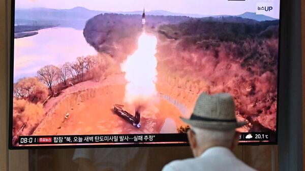 A man watches a television screen showing a news broadcast with file footage of a North Korean missile test, at a train station in Seoul on June 26, 2024. - Sputnik Africa