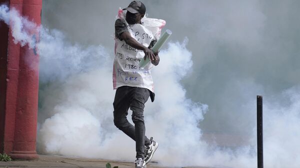 A protester returns back a teargas canister to Kenya police in Nairobi, Kenya Thursday, June 27, 2024. - Sputnik Africa