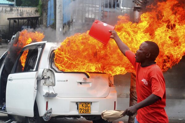 A member of the public calls for reinforcement as protesters set vehicles on fire in Mombasa, Kenya Tuesday, July 2, 2024. - Sputnik Africa