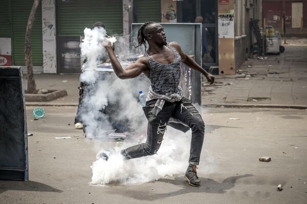 A protester throws a tear gas canister back to Kenya Police officers amid clashes during an anti-government demonstration called following nationwide deadly protests over tax hikes and a controversial now-withdrawn tax bill in downtown Nairobi, on July 2, 2024. - Sputnik Africa