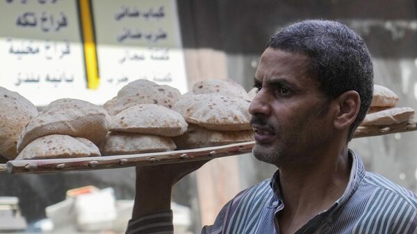 A man carries a bread tray at a popular market in Cairo, Egypt, Friday, June 7, 2024.  - Sputnik Africa