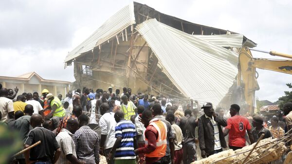 People and rescuers gather at the scene of a collapsed two-storey building in Jos, Nigeria, Friday, July, 12, 2024. - Sputnik Africa