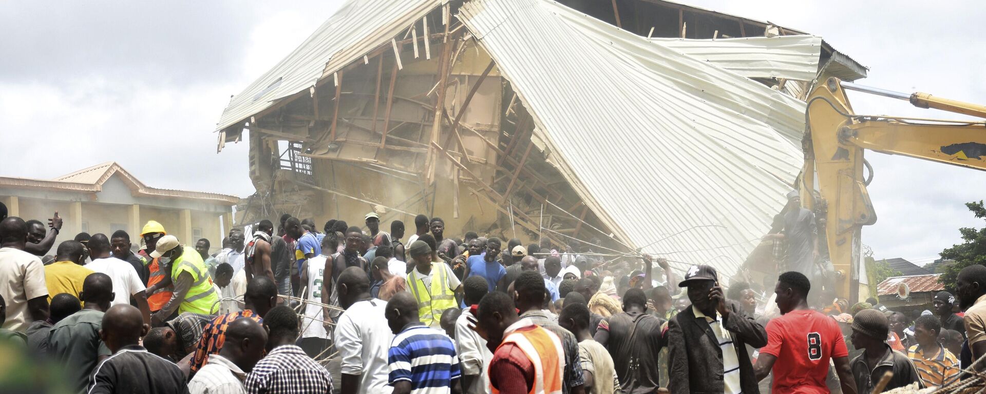 People and rescuers gather at the scene of a collapsed two-storey building in Jos, Nigeria, Friday, July, 12, 2024. - Sputnik Africa, 1920, 13.07.2024