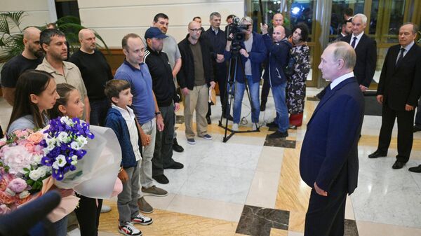 Russian President Vladimir Putin meets Russian citizens released after the Russian-US prisoner swap in Turkiye at Vnukovo International Airport in Moscow, Russia. - Sputnik Africa