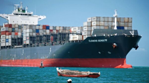 A fisherman rows past the Singapore-flagged Clemens Schulte cargo ship as it arrives in Dar es Salaam, Tanzania, on August 27, 2015.  - Sputnik Africa