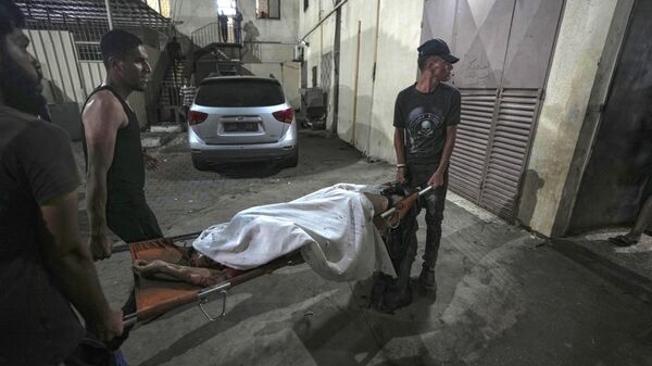 Palestinians carry the body of a victim of an Israeli strike that hit a tent area in the courtyard of Al Aqsa Martyrs hospital in Deir al Balah, Gaza Strip, Sunday, Aug. 4, 2024.  - Sputnik Africa