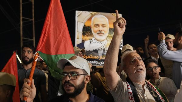 A demonstrator holds a picture of Hamas leader Ismail Haniyeh, who was killed in Tehran, during a rally in Baghdad, Iraq, on Saturday, Aug. 3, 2024, to show support for Palestinians in Gaza and to condemn the killing of Haniyeh.  - Sputnik Africa