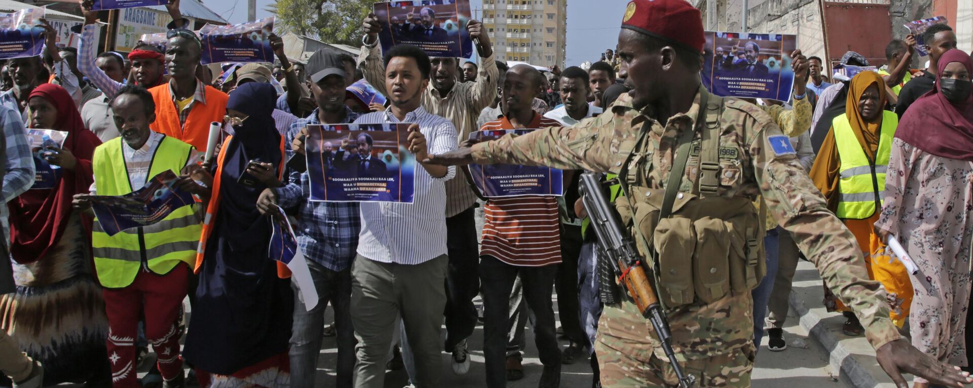 A Somali soldier controls the crowd as thousands of people attend a protest rally in Mogadishu, Somalia, after being angry with an agreement signed between Ethiopia - Sputnik Africa, 1920, 14.08.2024