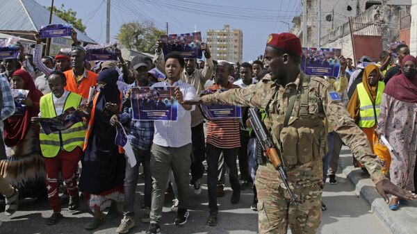 A Somali soldier controls the crowd as thousands of people attend a protest rally in Mogadishu, Somalia, after being angry with an agreement signed between Ethiopia - Sputnik Africa