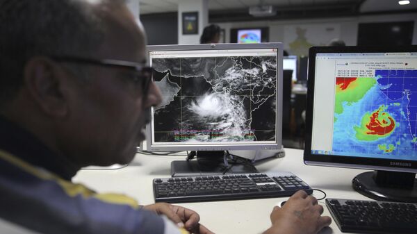 A staffer monitors Cyclone Vayu at a cyclone monitoring center at the Indian Meteorological Department office in New Delhi, India - Sputnik Africa