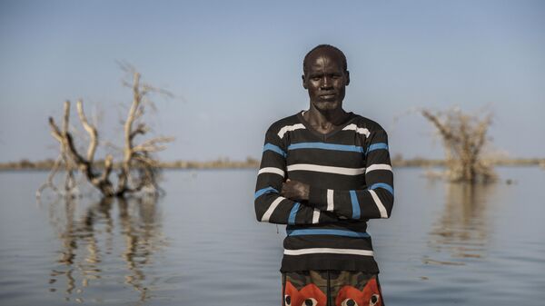 Cette photohraphie de Luke Dray est intitulée La réalité climatique du Soudan du Sud. Elle fait partie des finalistes du concours international de photojournalisme Stenine 2024. John Malesh, 40 ans, pose pour un portrait là où se trouvait autrefois sa maison, le 29 novembre 2023 à Tong, au Soudan du Sud. Lui et sa famille vivent sur un petit terrain surélevé, entouré d’eaux de crue, depuis que leurs champs ont été inondés en 2021. Lorsqu’on l’interroge sur la menace d’El Niño pour l’année prochaine, il répond :  S’il pleut beaucoup cette année, cette terre ne sera plus là.  - Sputnik Afrique