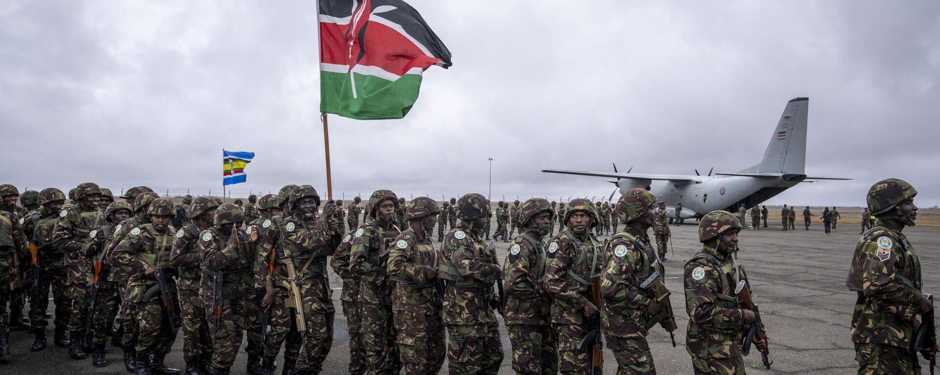 Members of the Kenya Defence Forces (KDF), one holding a national flag, line up to board transport aircraft as they deploy to Goma in eastern Congo as part of the East African Community Regional Force (EACRF), at a military airport in Nairobi, Kenya Wednesday, Nov. 16, 2022.  - Sputnik Africa, 1920, 26.08.2024