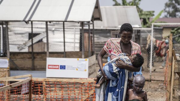 A woman walks with her children suffering from mpox after a treatment at a clinic in Munigi, eastern Congo - Sputnik Africa