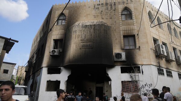 Palestinians stand outside a heavily damaged mosque following an Israeli military operation in the West Bank refugee camp of Al-Faraa - Sputnik Afrique