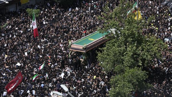 Iranians follow a truck carrying coffins of the late President Ebrahim Raisi and his companions who were killed in a helicopter crash on Sunday in a mountainous region of the country's northwest, during a funeral ceremony for them in Tehran, Iran, Wednesday, May 22, 2024. - Sputnik Africa