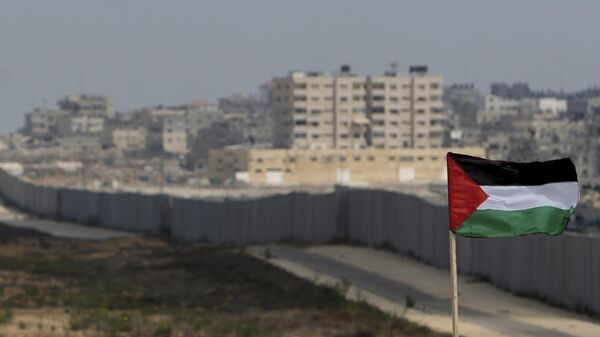 FILE - A Palestinian flag is seen with the background of a section of the wall in the Philadelphi corridor between Egypt and Gaza, on the background, near the southern Gaza Strip town of Rafah. - Sputnik Africa