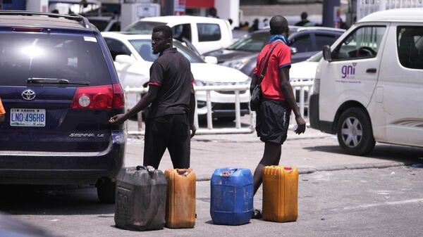 People sell fuel outside a petrol station in Lagos, Nigeria, Tuesday April 30, 2024. Nigerians were queuing for hours to buy fuel across major cities on Tuesday as the West African nation faced its latest fuel shortage, resulting in increased hardship for millions already struggling with the country's economic crisis. - Sputnik Africa