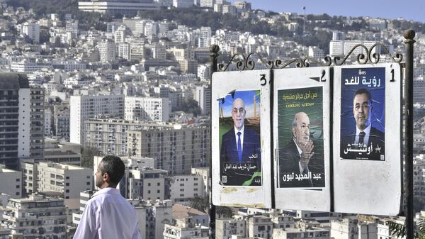 A man walks past electoral banners of presidential candidate, including President Abdelmadjid Tebboune, center, Tuesday, Aug. 27, 2024, in Algiers, Algeria. - Sputnik Africa