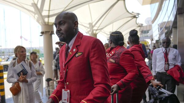 Kenya airways flight attendants queue alongside stranded passengers waiting for their delayed flights out of JKIA airport after flights were grounded following workers’ protesting a planned deal between the government and a foreign investor, in Nairobi, Kenya, Wednesday, Sept. 11, 2024. - Sputnik Africa