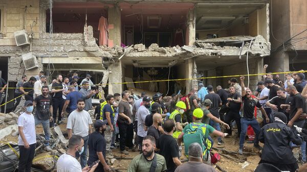 People gather near a damaged building at the scene of an Israeli missile strike in the southern suburbs of Beirut - Sputnik Africa