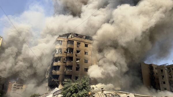 Smoke rises as a building collapses in Beirut's southern suburbs, Saturday, Sept. 28, 2024. - Sputnik Africa