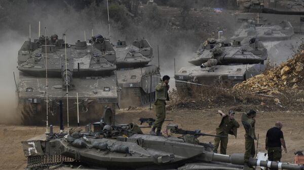 Israeli army tanks manoeuvre in a staging area in northern Israel near the Israel-Lebanon border, Tuesday, Oct. 1, 2024. - Sputnik Africa