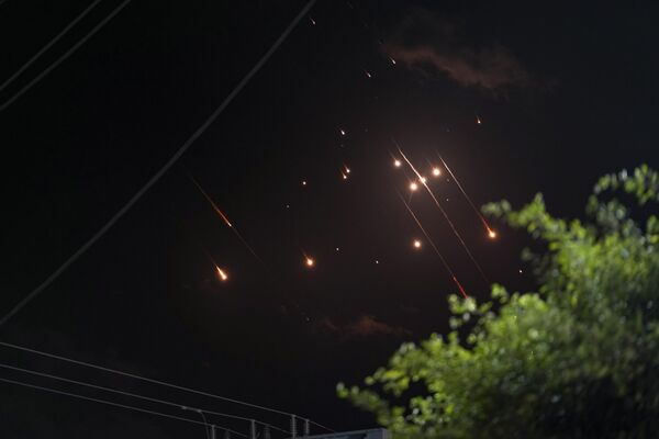 Missiles launched from Iran towards Israel streak across the night sky, as seen from Deir al-Balah, Gaza Strip, Tuesday, Oct. 1, 2024. (AP Photo/Abdel Kareem Hana) - Sputnik Africa