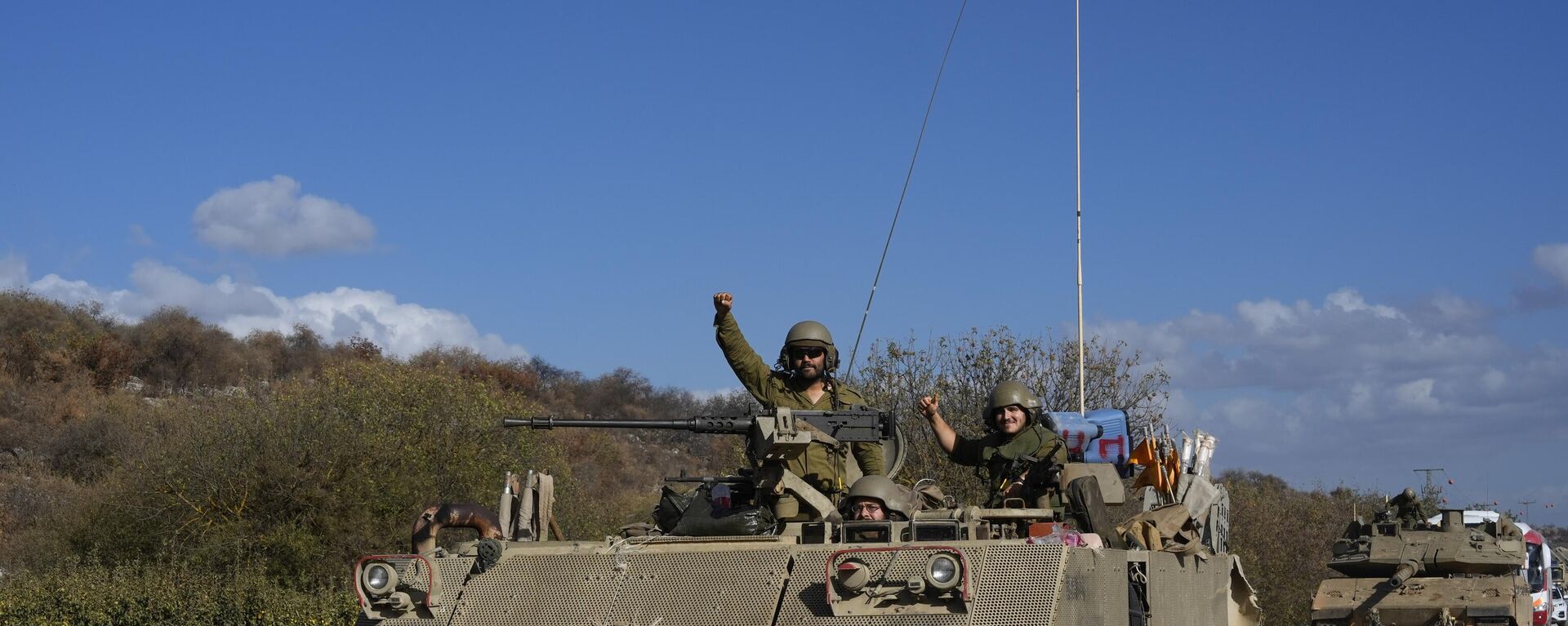 Israeli soldiers raise their fists from a moving APC in northern Israel near the Israel-Lebanon border, Tuesday, Oct. 1, 2024.  - Sputnik Africa, 1920, 02.10.2024