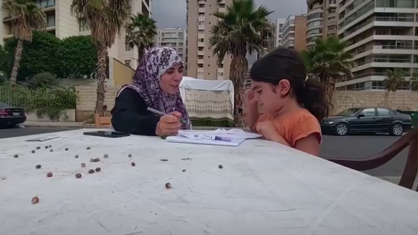 L'enseignante libanaise Fatimah Khalil avec sa fille sur une plage à Beyrouth - Sputnik Afrique