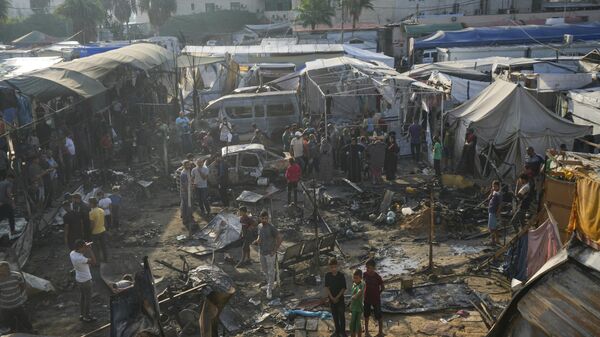 Palestinians look at the damage after an Israeli strike hit a tent area in the courtyard of Al Aqsa Martyrs hospital in Deir al Balah, Gaza Strip, Monday, Oct. 14, 2024.  - Sputnik Africa